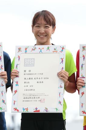 成年女子８００メートルで５位に入り、表彰台の上で笑顔を見せる山田はな（わらべや日洋）＝佐賀市