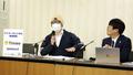 提訴後に記者会見する原告の男性(左)と代理人弁護士=4月21日、東京都内