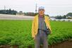 　自宅周辺に広がるニンジン畑に立つ栗原恒治さん＝１１月、千葉県富里市