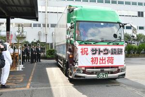 サトウ食品の鏡餅を積み出発するトラック＝２９日、新発田市