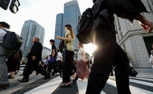 　東京・丸の内を行き交う人たち＝７月