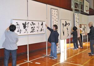 南魚美術協会会員展開催を前に展示作業を行う出品者ら=南魚沼市浦佐のB&G体育館