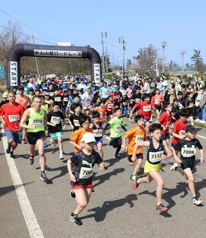 声援を受け、元気にスタートするランナーたち=4月14日、上越市柿崎区