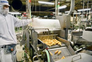 販売が好調に推移した岩塚製菓の主力米菓「田舎のおかき」の製造ライン=長岡市
