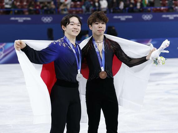 日の丸を背に笑顔を見せる、男子で銀メダルの鍵山優真（左）と銅メダルの佐藤駿＝ミラノ（共同）