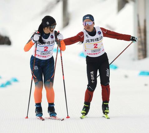 女子４×３キロリレー　３走の丸山友奈（黄・右）がアンカーの柳里緒菜（青）へリレー＝６日、長野県の野沢温泉南原クロスカントリーコース