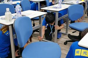 防災訓練で机の下に隠れる学習塾講師=2日午前、大阪市鶴見区