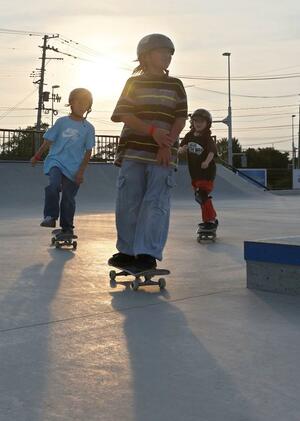 夕日を背にしてスケートボードを楽しむ子どもたち＝６月２０日、新潟市中央区のＡＩＲＭＡＮスケートパーク