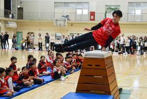 母校の千葉・市船橋高で体操教室に参加し、跳び箱の上であん馬の旋回を披露する橋本大輝=2日