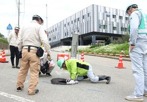 市道の陥没部分を調査する市職員ら=22日、佐渡市梅津