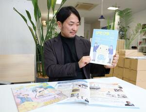 中学生向け進路情報誌の「ジモクラJr.」を手に取る山口芳春さん=柏崎市東本町1