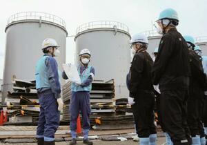 東京電力福島第1原発の処理水タンクの解体作業を視察する原子力規制委の杉山智之委員(左から3人目)=12日(同委員会提供)