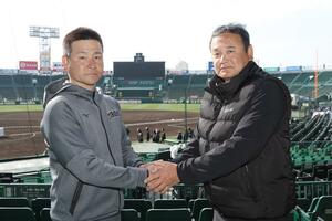 握手を交わす帝京長岡の芝草宇宙監督（右）と東北の我妻敏監督＝甲子園球場