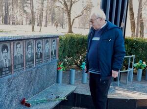 　チョルノービリ原発事故で犠牲となったブラジニクさんの遺影に花を手向けるゲオルギー・チトフさん＝３月、ウクライナ・スラブチチ（共同）