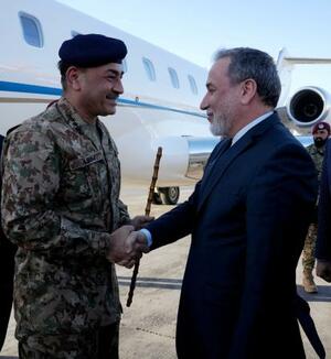 15日、イランの首都テヘランの空港で、アラグチ外相(右)に迎えられるパキスタンのムニール陸軍元帥(ロイター=共同)