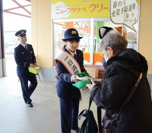 ティッシュを配り、火の用心を呼びかける一日消防署長の塩川優羽さん=3月31日、十日町市山本町5