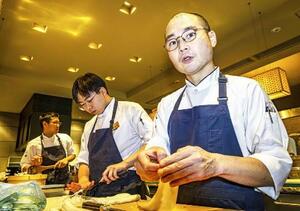 「六雁」のオープンキッチンで後輩たちと仕込み作業中の佐藤実。以前に比べ物腰が穏やかになってきた=2025年11月、東京・銀座