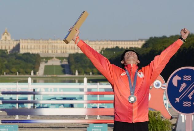 近代五種男子で銀メダルを獲得し、表彰式で喜ぶ佐藤大宗。奥はベルサイユ宮殿＝パリ郊外（共同）
