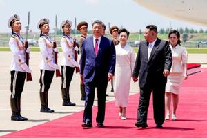 平壌に到着し北朝鮮の金正恩朝鮮労働党総書記(手前右)と歩く中国の習近平国家主席(同左)=8日(新華社=共同)