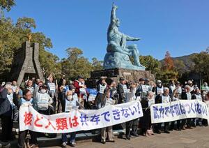 長崎市の平和公園で行われた核兵器廃絶を求める集会で、シュプレヒコールを上げる被爆者ら=9日