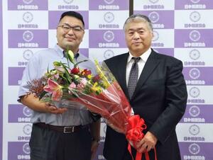 大嶽部屋を継承する熊ケ谷親方(左)から花束を受け取る大嶽親方=26日、両国国技館