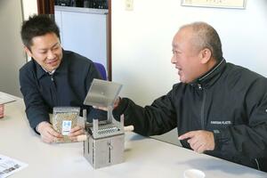 発売したコーヒーロースターを紹介する川﨑社長の川﨑雄輔さん（右）と営業部の社員＝三条市下保内