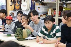 　修学旅行に向けた話し合いで発言する、南アルプス子どもの村小中学校教員の禰津匡人さん（右から３人目）と生徒＝２３日、山梨県南アルプス市