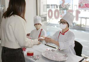 献血に協力した人にチョコを手渡す専門学生=13日、新潟市中央区万代1