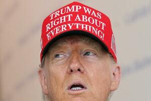 　「トランプは全てにおいて正しかった」と書いた帽子をかぶるトランプ米大統領＝２２日、ワシントン（ロイター＝共同）