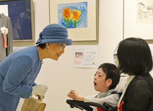 日本肢体不自由児協会が主催する美術展と写真展を鑑賞された常陸宮妃華子さま。中央はヒマワリの絵を描いた永田悠人さん=3日午前、東京都豊島区