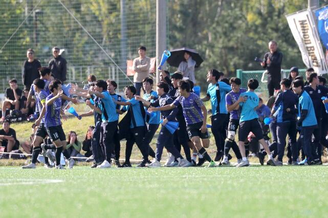 東京学館－日本文理　後半１９分、ＤＦ谷会煌祇（日本文理）の同点ゴールで１－１とし、入り乱れる選手と応援団＝１０月２６日、新潟県北蒲原群聖籠町東港５の新潟聖籠スポーツセンター