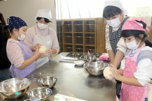 親と一緒に、パンの生地をこねる子どもたち=佐渡市両津夷