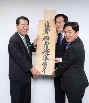 　「福島復興浜通りセンター」の開所式で看板を掛ける牧野復興相（左）＝２４日午後、福島県双葉町