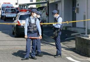 女性の遺体が見つかった集合住宅の前に立つ警察官=30日、愛知県豊田市