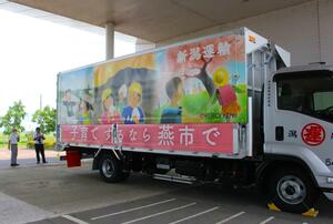 つばめっ子かるたの絵札を基にしたデザインが目を引く新潟運輸のラッピングトラック=燕市役所