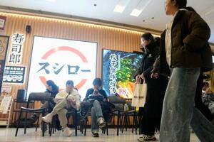 　北京市中心部のショッピングセンターにある、回転ずしの「スシロー」で入店を待つ人たち＝１月（共同）