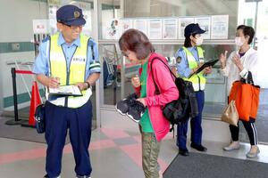 高齢者に交通事故防止に関する考えや意見を尋ねる新潟西署の署員=新潟市西区五十嵐1の町