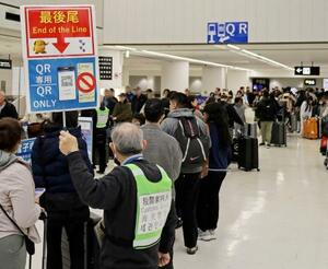 税関の電子手続きを待つ入国者らが長蛇の列をなす成田空港=2月(人物の顔を画像加工で消しています)