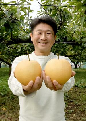 ISSに届けられたナシ「新興」と生産者の土田広樹さん=三条市井戸場