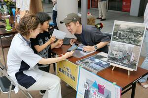 今昔モザイクアートプロジェクトのワークショップ。参加者が昔の写真を手がかりに、今の写真を撮影した=6月16日、新潟市中央区古町通7