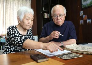 家族写真を見て思い出を語る熊倉陽子さん(左)と夫の勝さん