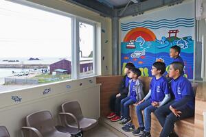 完成した待合室から日本海を眺める米山小の児童=柏崎市笠島