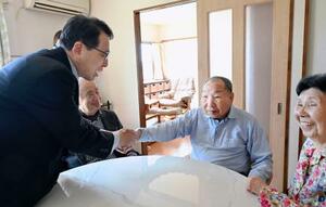 　袴田巌さんと握手を交わす村山浩昭元裁判官（左）＝２７日午後、浜松市