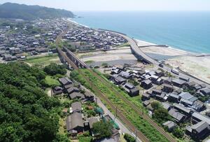 海に面した山北地区。川の手前に岩崎集落、奥に府屋集落が広がる=村上市(本社小型無人機から)
