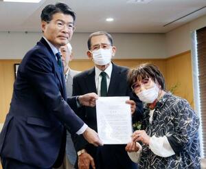 被爆体験者の岩永千代子さん(右)らから早期救済に向けた要望書を受け取る長崎県の平田研知事=11日午後、長崎県庁