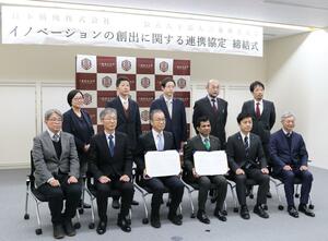 「イノベーションの創出に関する連携協定」を締結した新潟県の三条市立大学のアハメド・シャハリアル理事長(前列右から3人目)、日本精機の佐藤浩一社長(同4人目)ら関係者=新潟県三条市上須頃