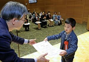 「わたしの日報抄」で優秀作に輝いた人に賞状が手渡された表彰式=5日、新潟市中央区
