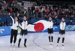 ミラノ・コルティナ冬季五輪のスピードスケート女子団体追い抜きで銅メダルを獲得し、日の丸を掲げ場内を回る(左から)堀川桃香、高木美帆、野明花菜、佐藤綾乃=17日、イタリア・ミラノ(共同)