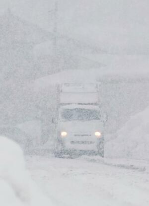 新潟５区内を街宣する選挙カー。大雪で候補者の名前はほとんど見えない＝２９日、上越市