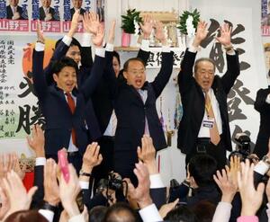 石川県知事選で初当選を決め、万歳する山野之義氏(中央)=8日深夜、金沢市